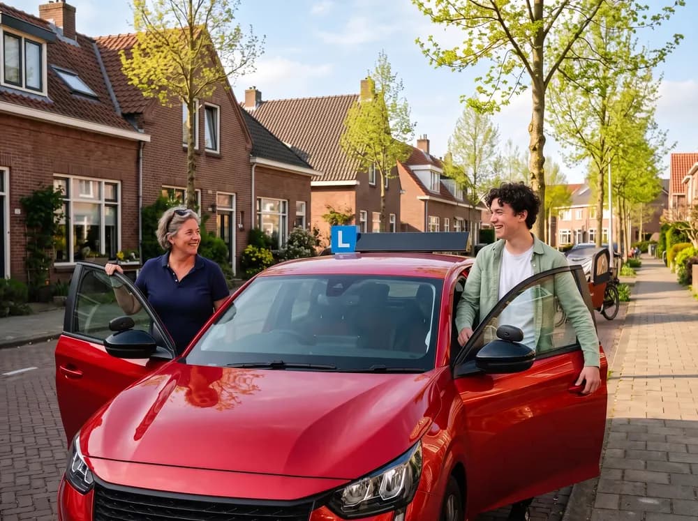 Leerling stapt lachend achter het stuur van de lesauto, de instructeur stapt aan de andere kant in