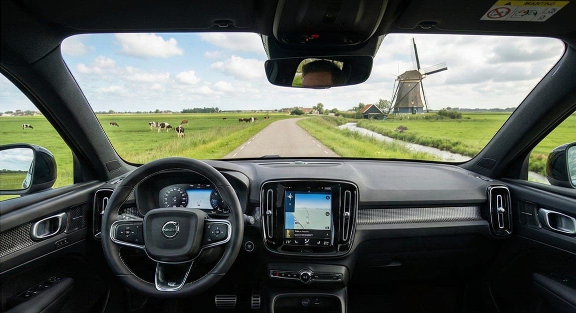 Dashboard van een lesauto in een polderlandschap